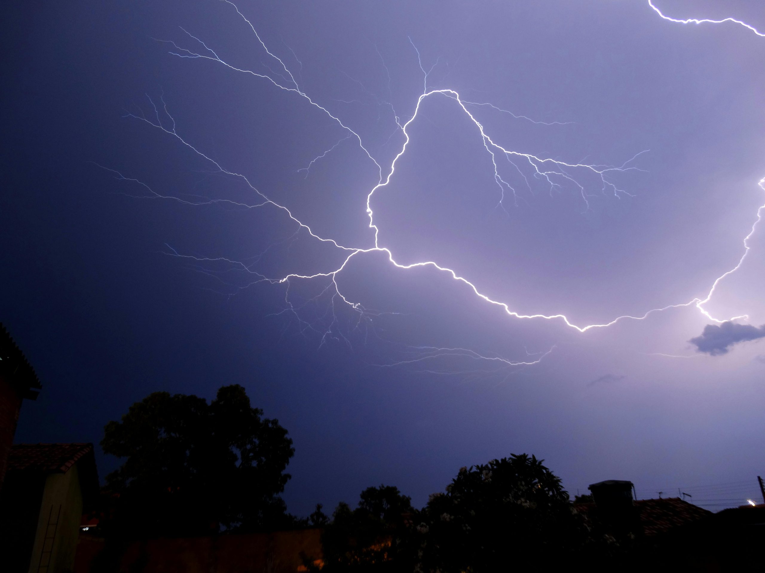 A bolt of lightning under a home during thunderstorm.