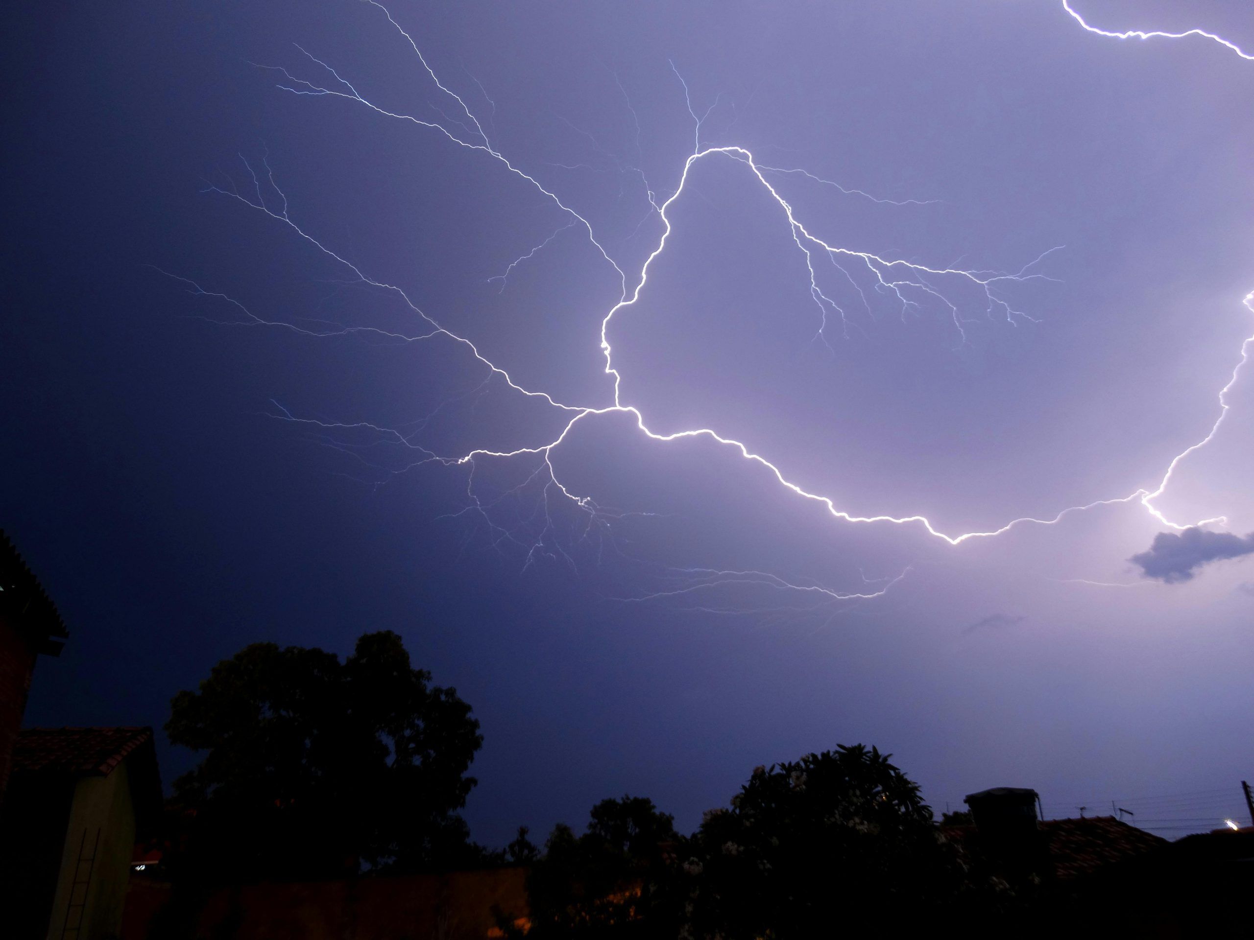 A bolt of lightning under a home during thunderstorm.
